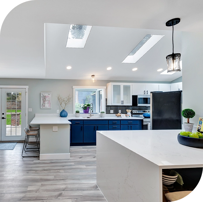 A kitchen with white cabinets and blue island.