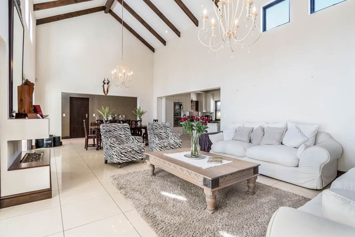 A living room with white furniture and a large window.